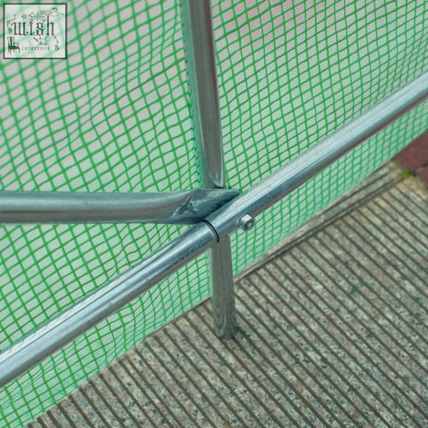 Green mesh safety net secured to galvanized metal steel frame of outsunny garden polytunnel greenhouse with large roll-up door