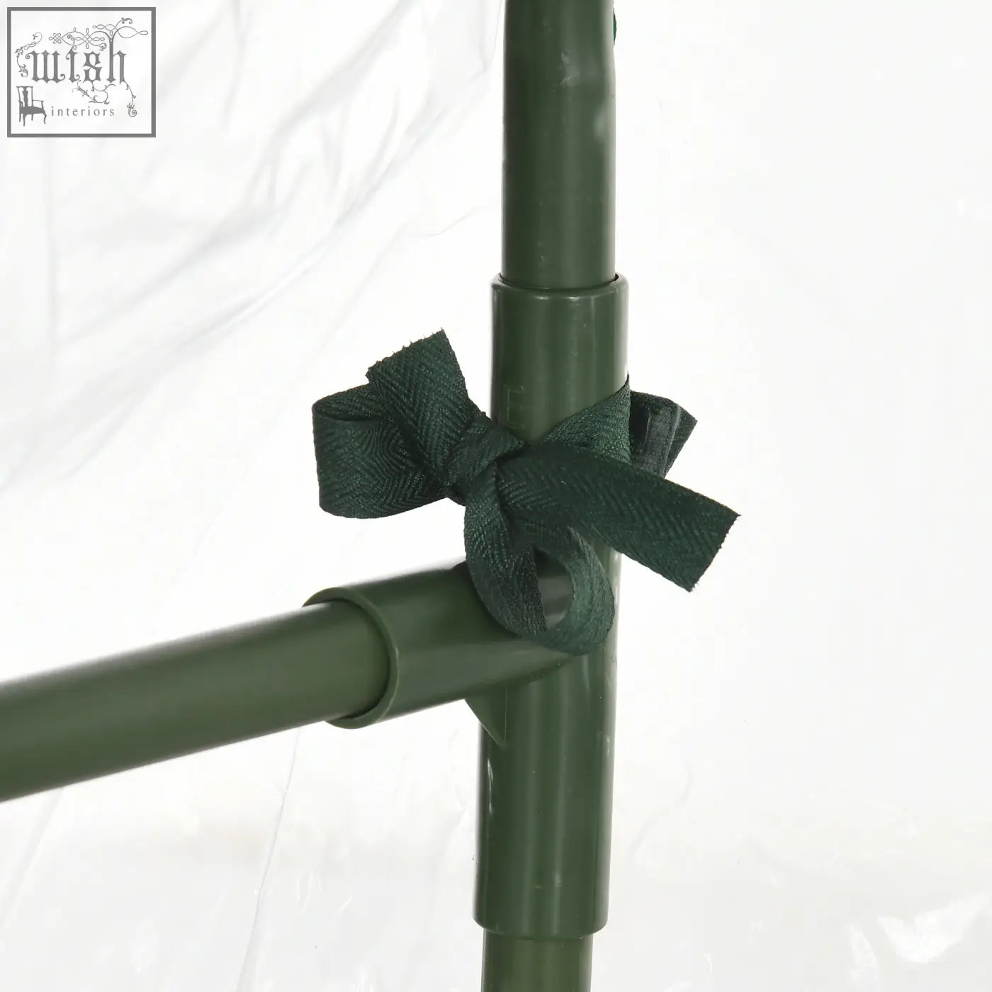 Dark green fabric bow tied around olive green steel frame poles providing extra stability for outsunny pvc greenhouse