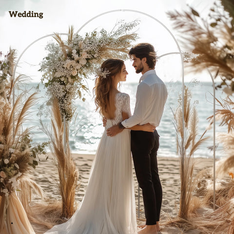 White lace wedding gown with flowing skirt and delicate back detailing next to outsunny wedding arch frame set in white metal