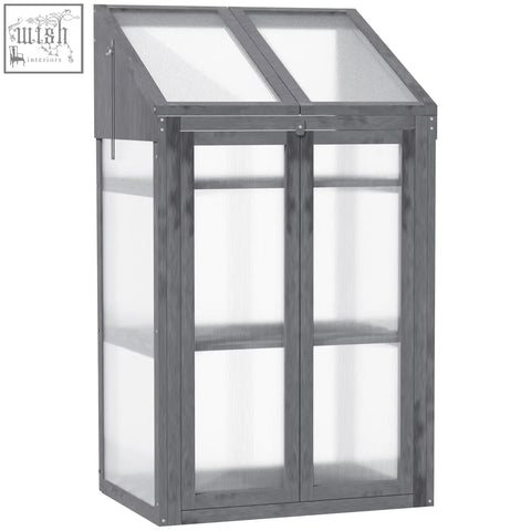Gray fir wood frame cold frame greenhouse with translucent panels and slanted roof for growing flowers and vegetables