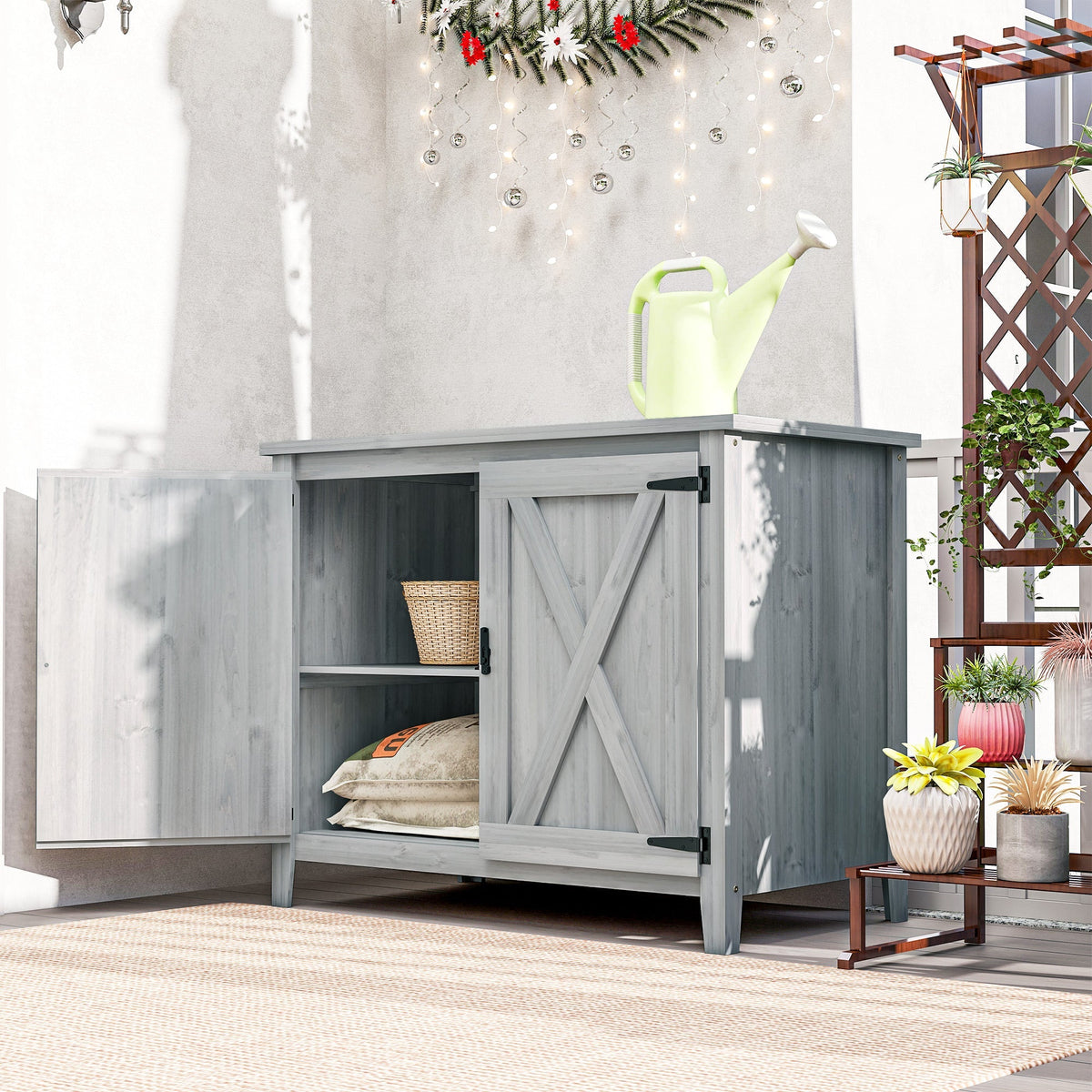 Gray wooden garden shed with x-shaped barn doors, black metal hinges, and built-in shelf for outdoor storage
