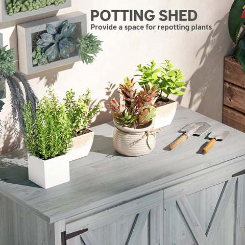 White ceramic pot with ribbed texture and twine accent in front of light grey outsunny wooden garden shed with barn doors and built-in shelf