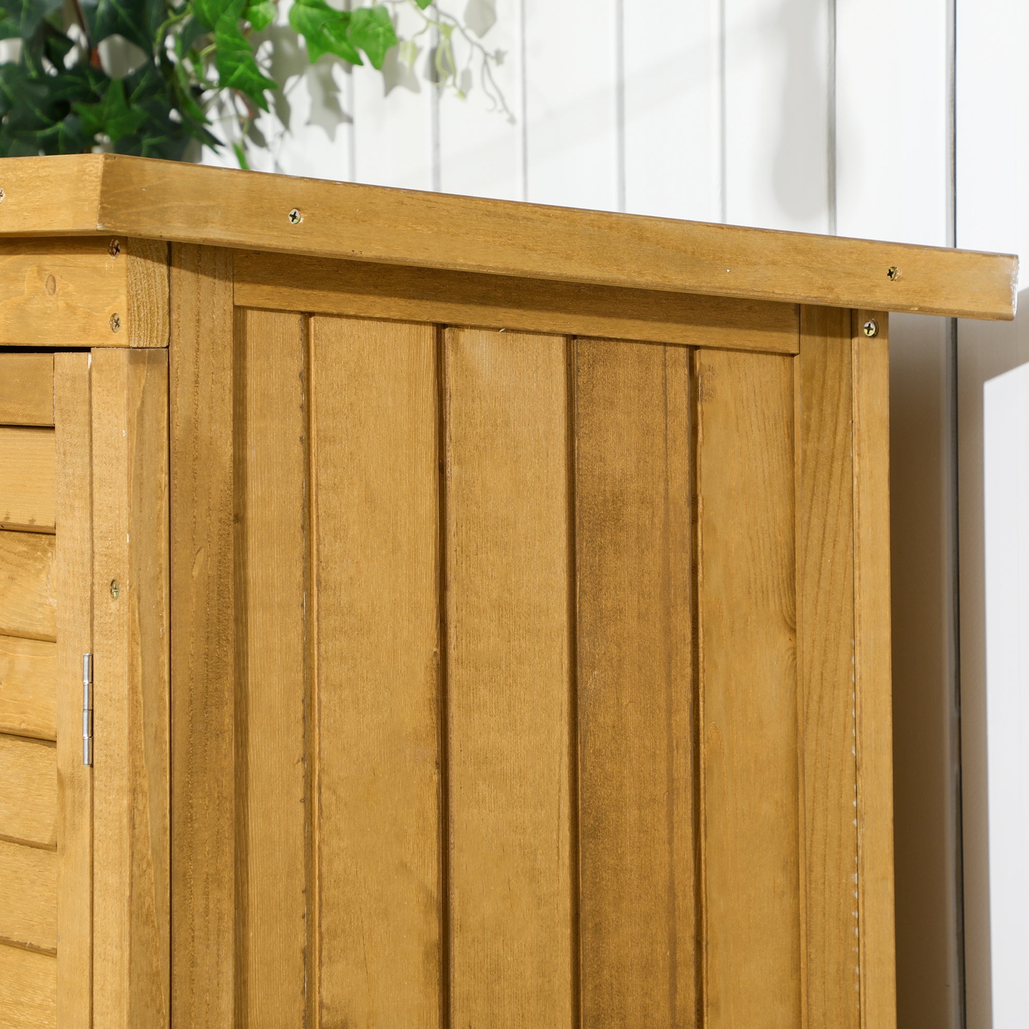 Light brown fir wood garden storage shed with vertical plank siding and asphalt roof for compact storage