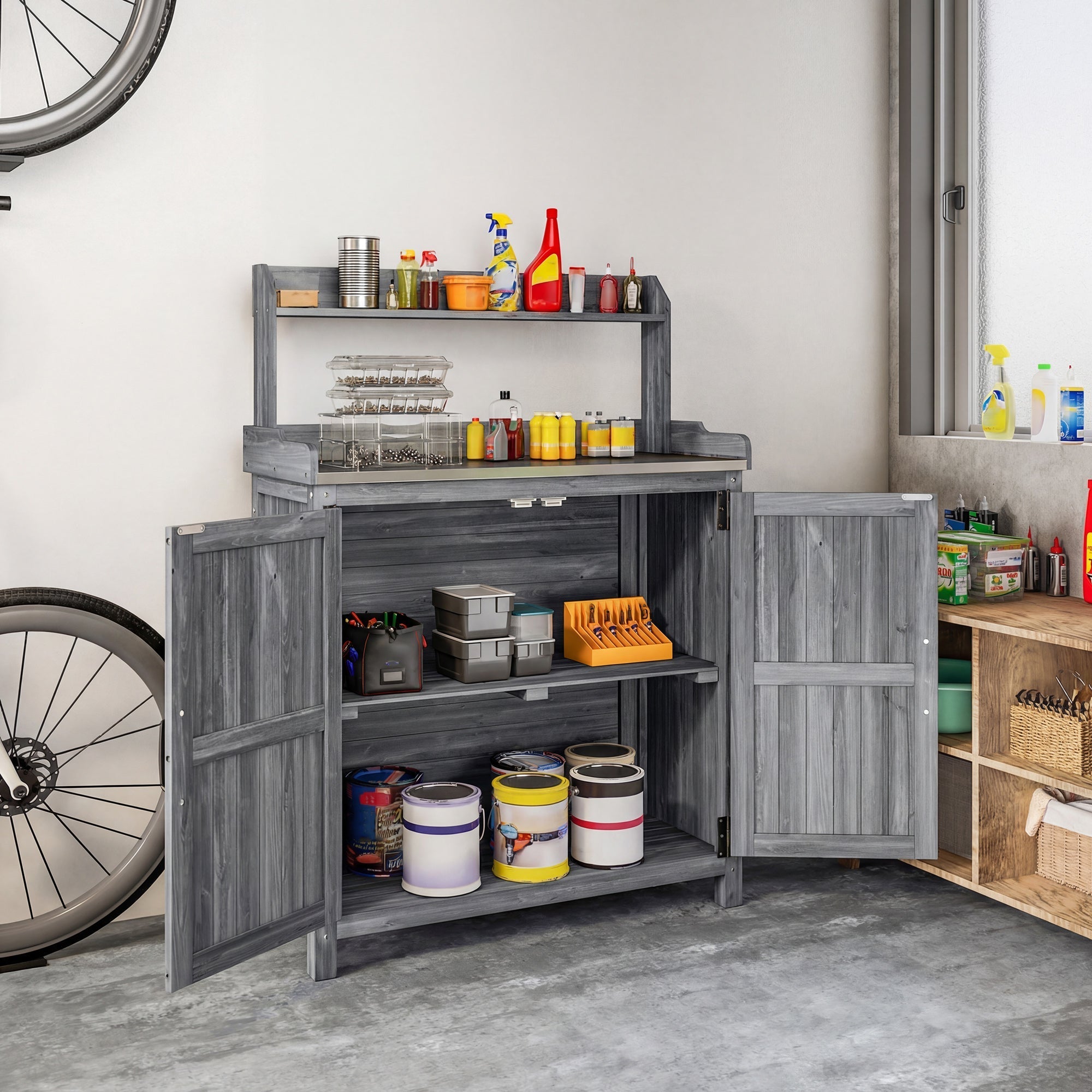 Gray wooden Outsunny potting bench table with open cabinet doors showing shelves holding paint cans and tools