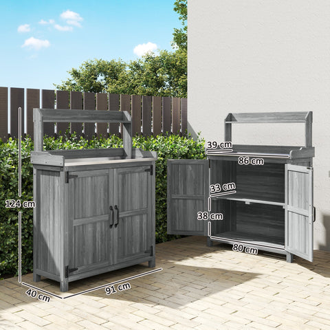 Gray wooden potting bench table with double doors and aluminum worktop for outdoor garden use with top shelf storage