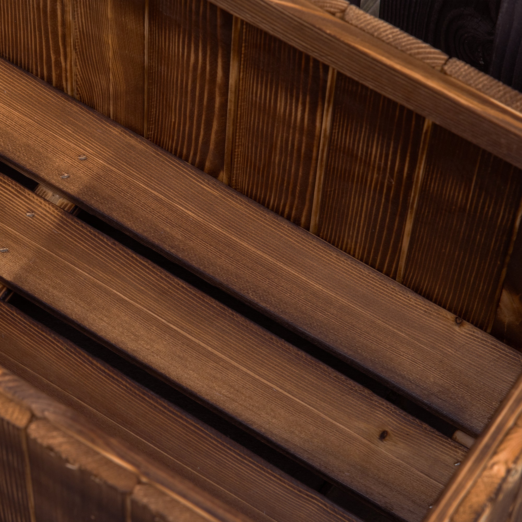 Dark brown fir wood planter box with visible grain and slatted design for raised garden bed outdoors