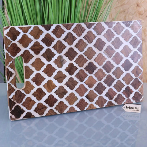 A rectangular ouzoud moroccan serving platter board with dark brown wood lattice inlays on a wooden cutting board
