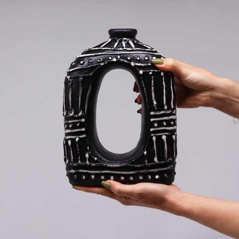 Black ceramic oval donut shaped vase with white geometric patterns and central oval cutout for dry flowers