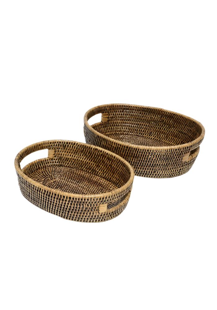 Set of two oval rattan baskets in brown with natural handles and textured woven finish for storage use