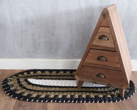 A triangular wooden dresser with three brass handled drawers in oval seagrass black white and tan classic 60x120cm design