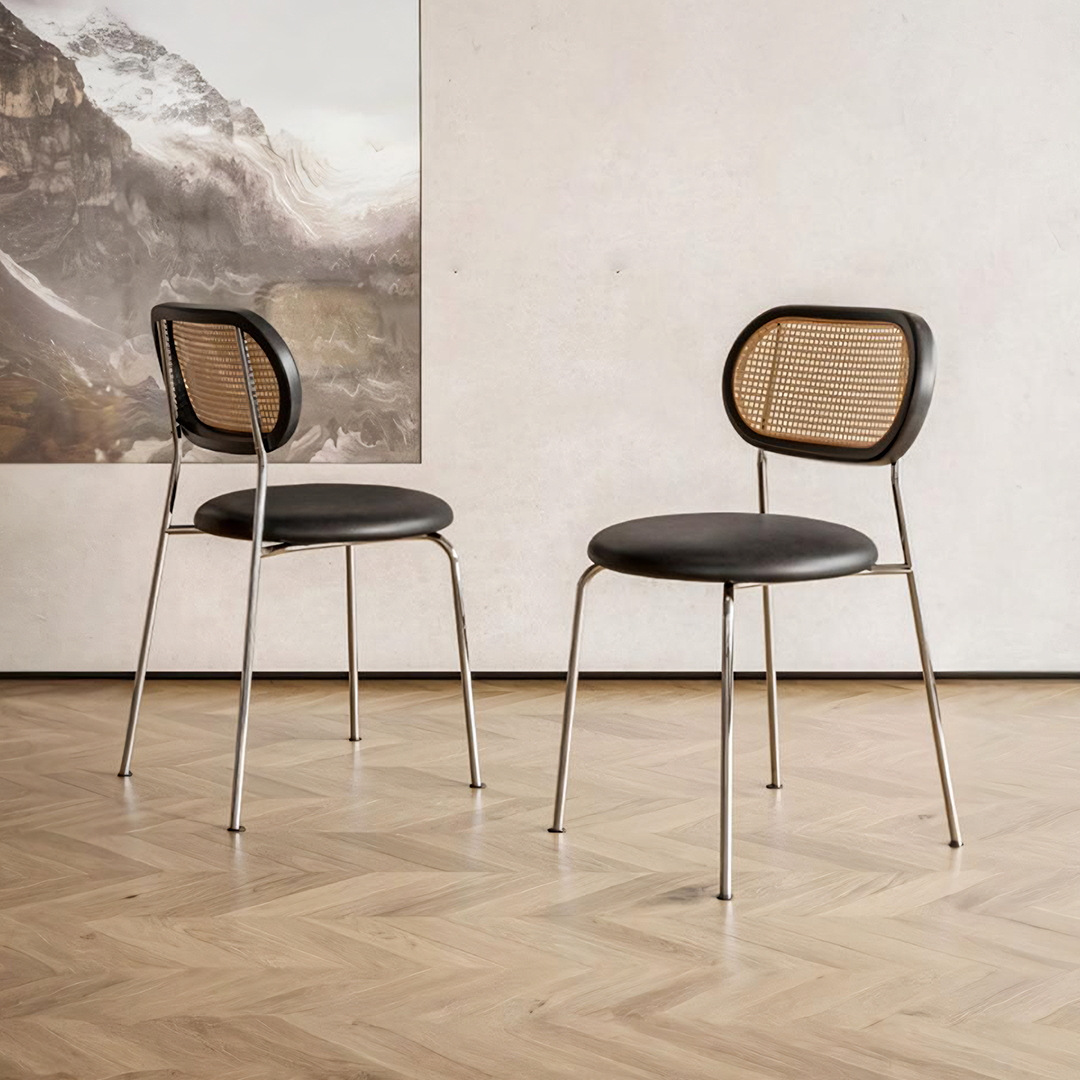 Black leather-seated ozzie rattan dining chair with woven cane back and chrome metal legs for stylish dining