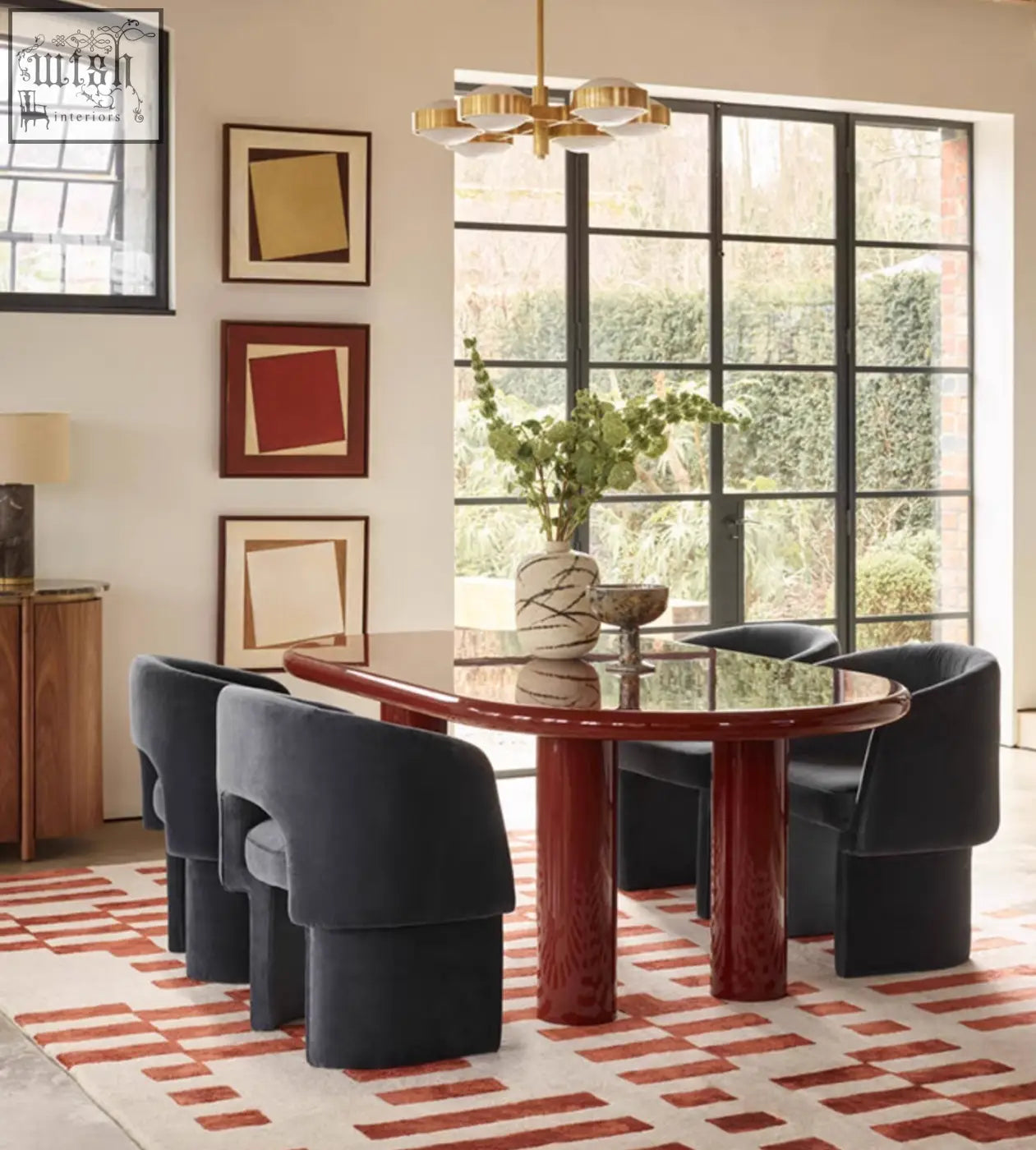 Paddy dining chair in velvet paired with a glossy marble dining table featuring curved red lacquered legs and reflective surface