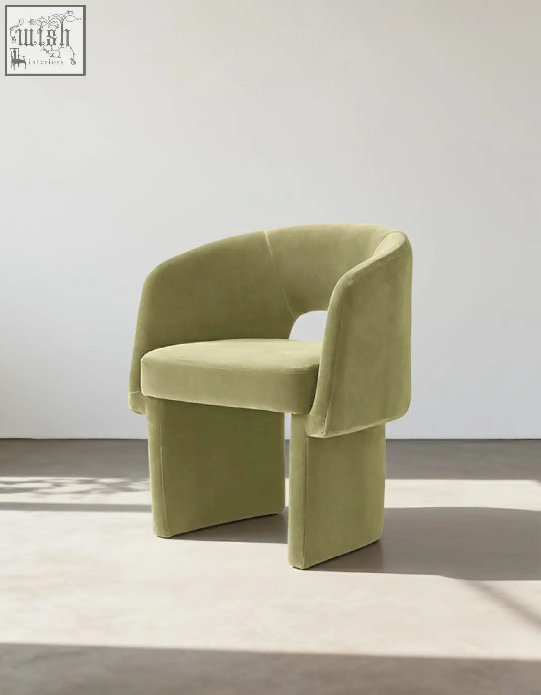 A modern olive green velvet paddy dining chair with sculpted legs perfect for a marble dining table setup