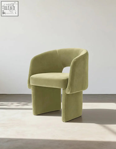 A modern olive green velvet paddy dining chair with sculpted legs perfect for a marble dining table setup