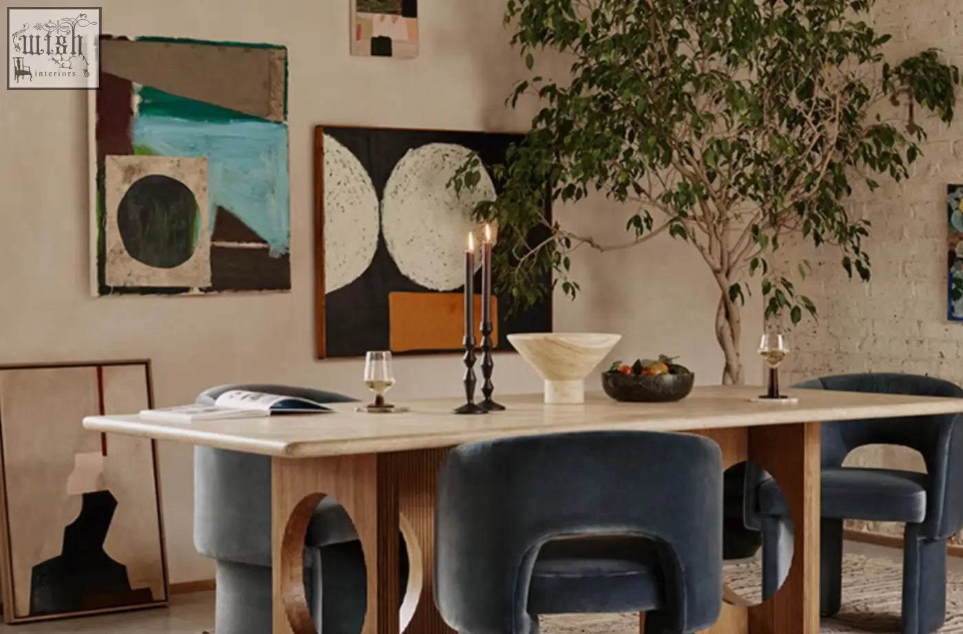 Modern marble dining table with light stone top and wooden legs paired with navy blue velvet paddy dining chair