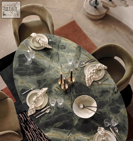 Oval green marble dining table with polished veined surface set with four paddy velvet dining chairs