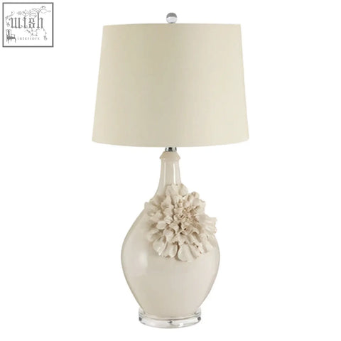 Cream-colored padma table lamp with sculpted floral accent and clear acrylic base for elegant lighting