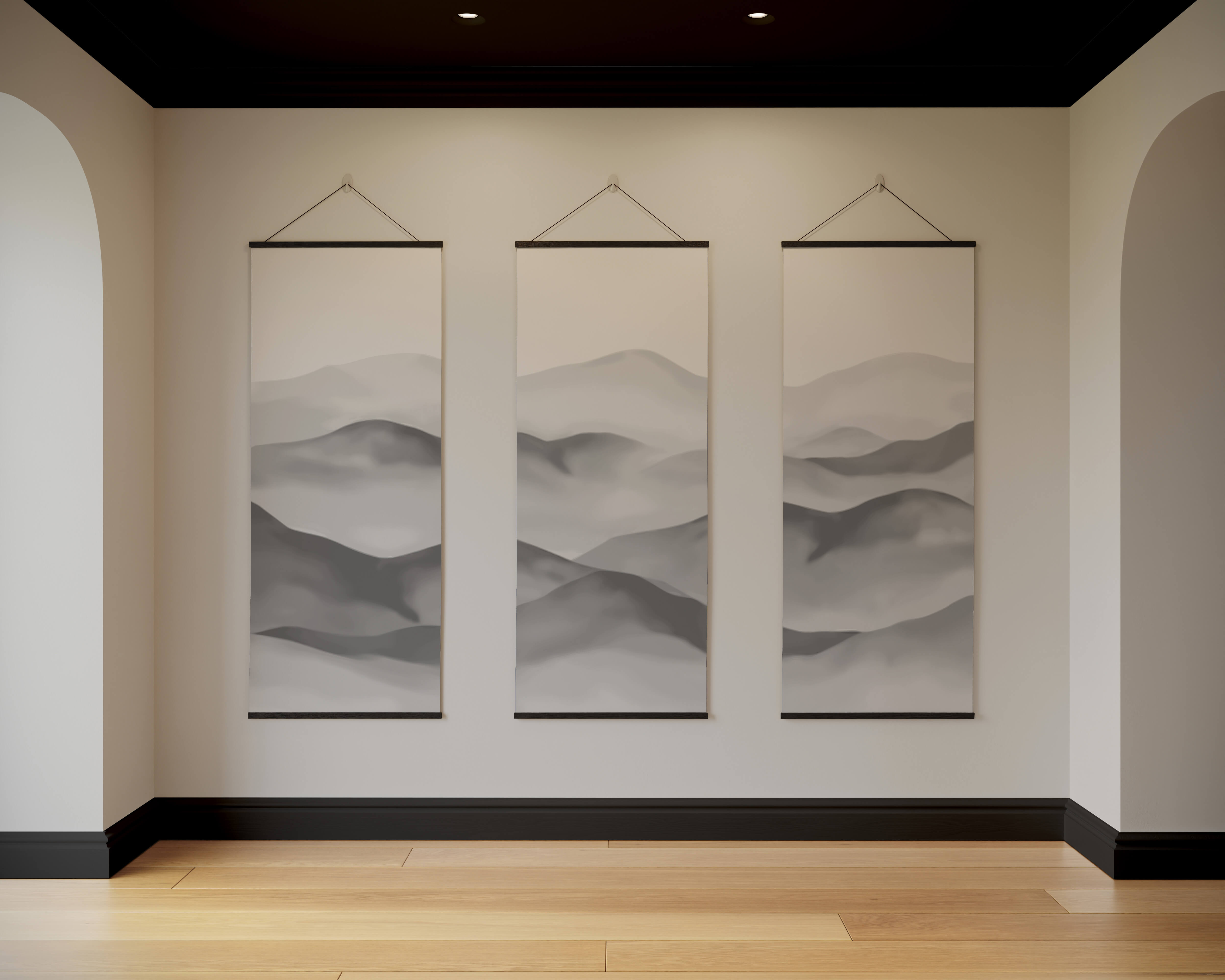 Three minimalist black-framed painted mountain tapestry scrolls hanging symmetrically on a beige art deco wall