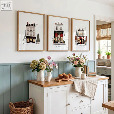 Three framed parisian-themed street scenes wall art with light wood frames above blue cabinet featuring pour toujours design