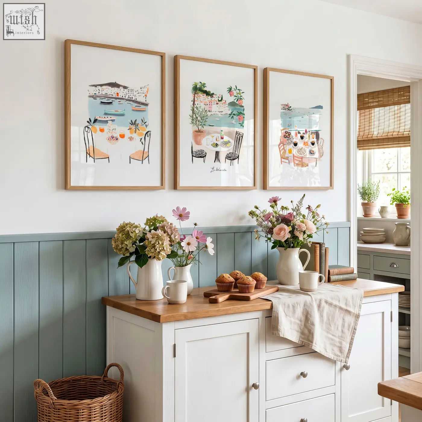 Three framed paintings with light wood frames hang above blue wainscoting for mediterranean coastal dining kitchen walls dolce vita