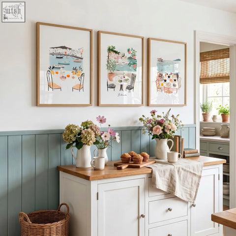 Three framed paintings with light wood frames hang above blue wainscoting for mediterranean coastal dining kitchen walls dolce vita