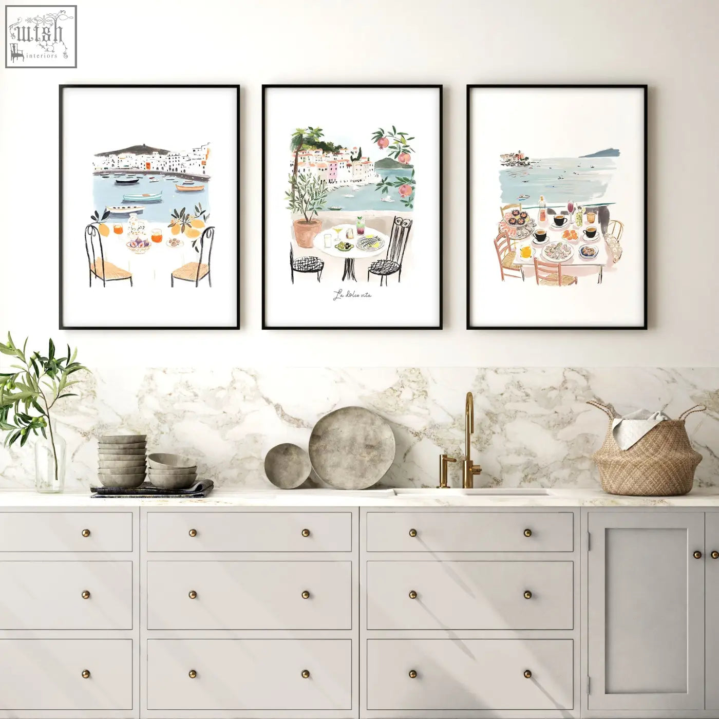 Three framed watercolor paintings of mediterranean coastal dining scenes hang above a marble kitchen wall countertop for dolce vita
