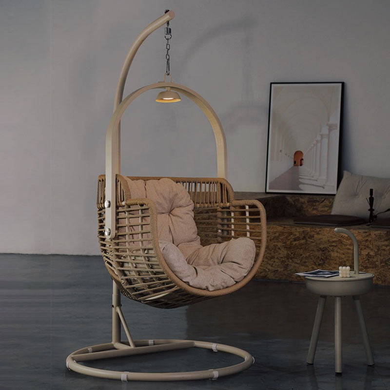 Beige paloma rattan garden hanging egg chair with cushioned seat suspended by arched metal frame for indoor outdoor use