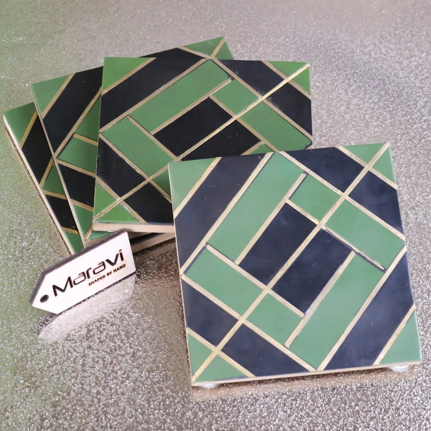 Set of four panna luxe resin coasters with green and navy geometric pattern and gold accents for stylish table use