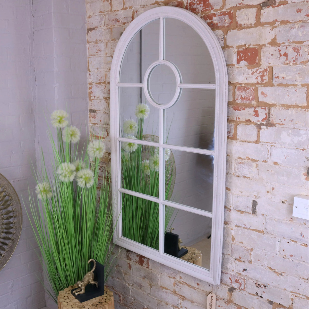 White arched window style mirror with circular center panel and divided glass sections in a white frame