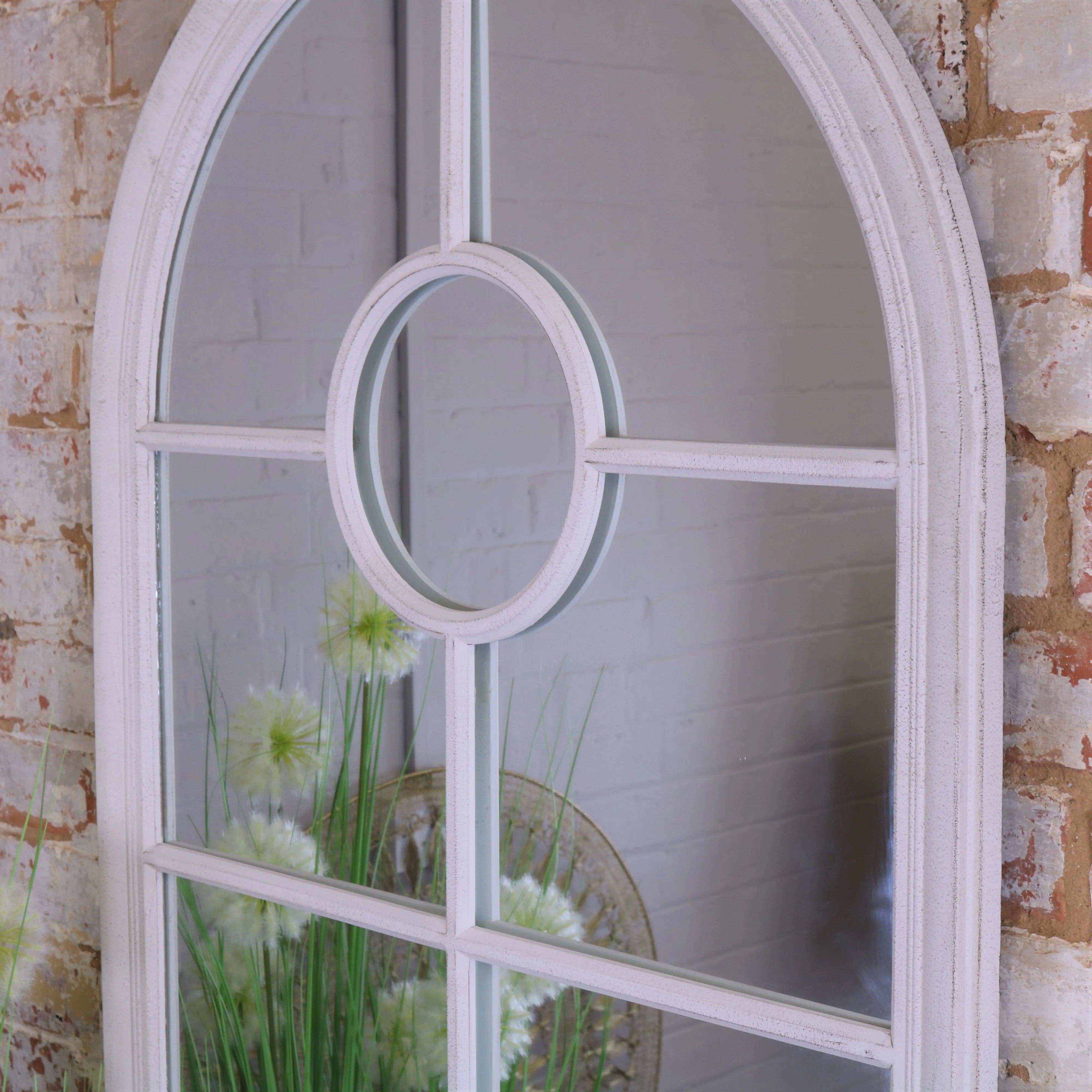 White arched window style mirror with distressed frame and circular center panel for rustic decor