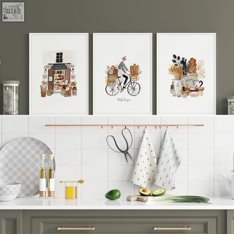 White patterned kitchen towels hanging from copper rack complement matin parisien wall art with brown tones