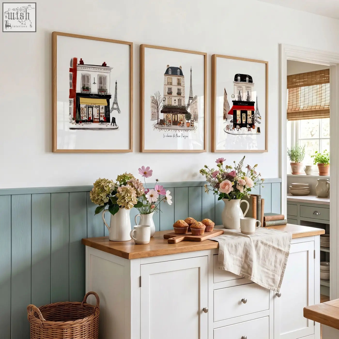Three framed paris café street scene kitchen art prints in light wood frames above white cabinet with wooden top