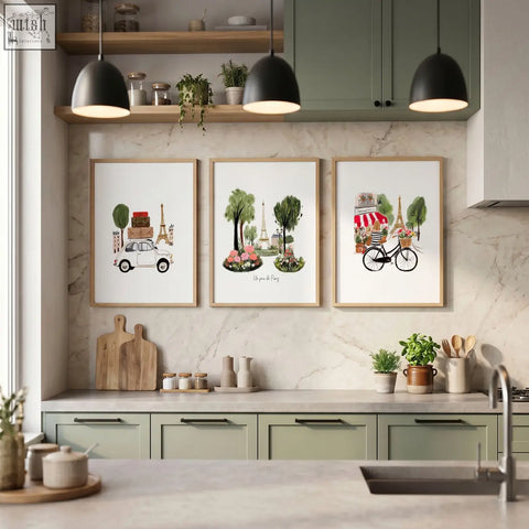 Three framed paris-themed art prints with light wood frames hang above kitchen cabinets on a marble wall for prints kitchen