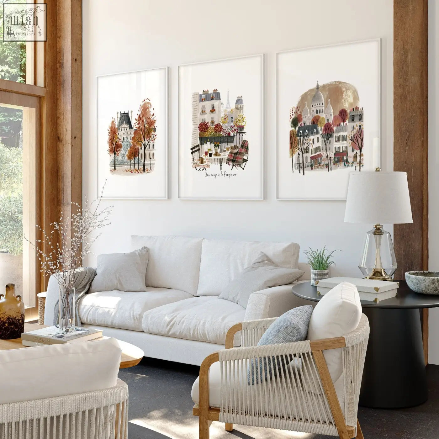 Three paris travel living room wall art prints with white mats and thin frames hang above a white sofa