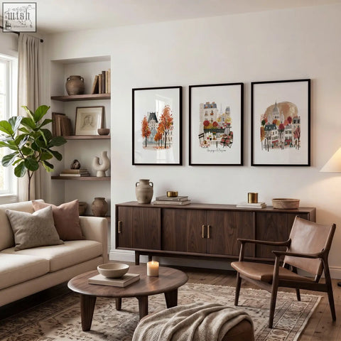 Dark wood mid-century modern sideboard with gold handles topped with books and vases in a living room with paris travel wall art prints