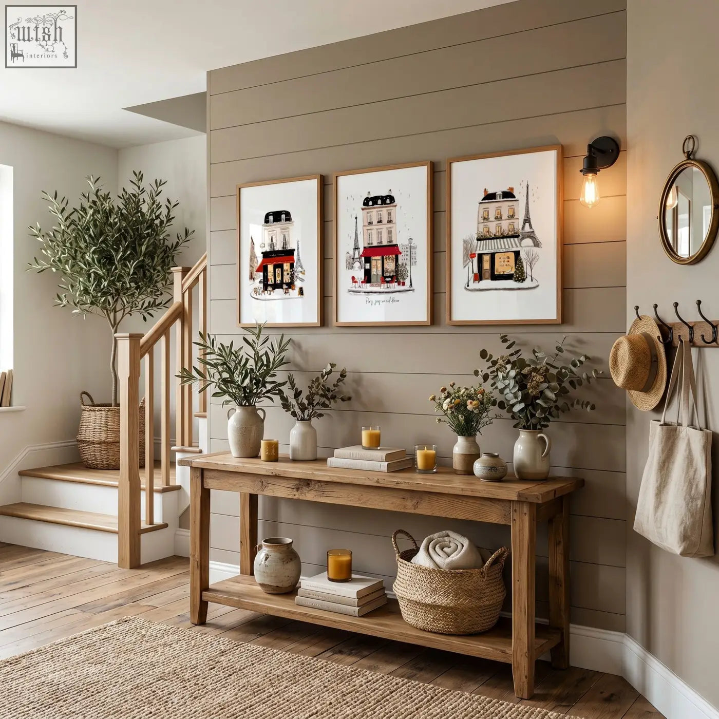 Rustic wooden console table with two shelves holding vases candles books and basket under paris travel wall art pieces set of 3