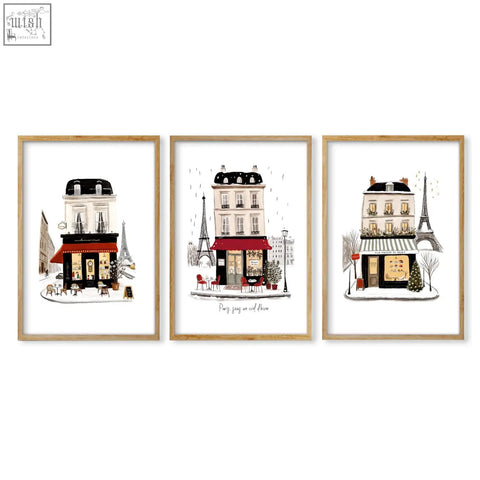 Set of three paris travel wall art pieces featuring illustrated street scenes in light wood frames perfect for decor