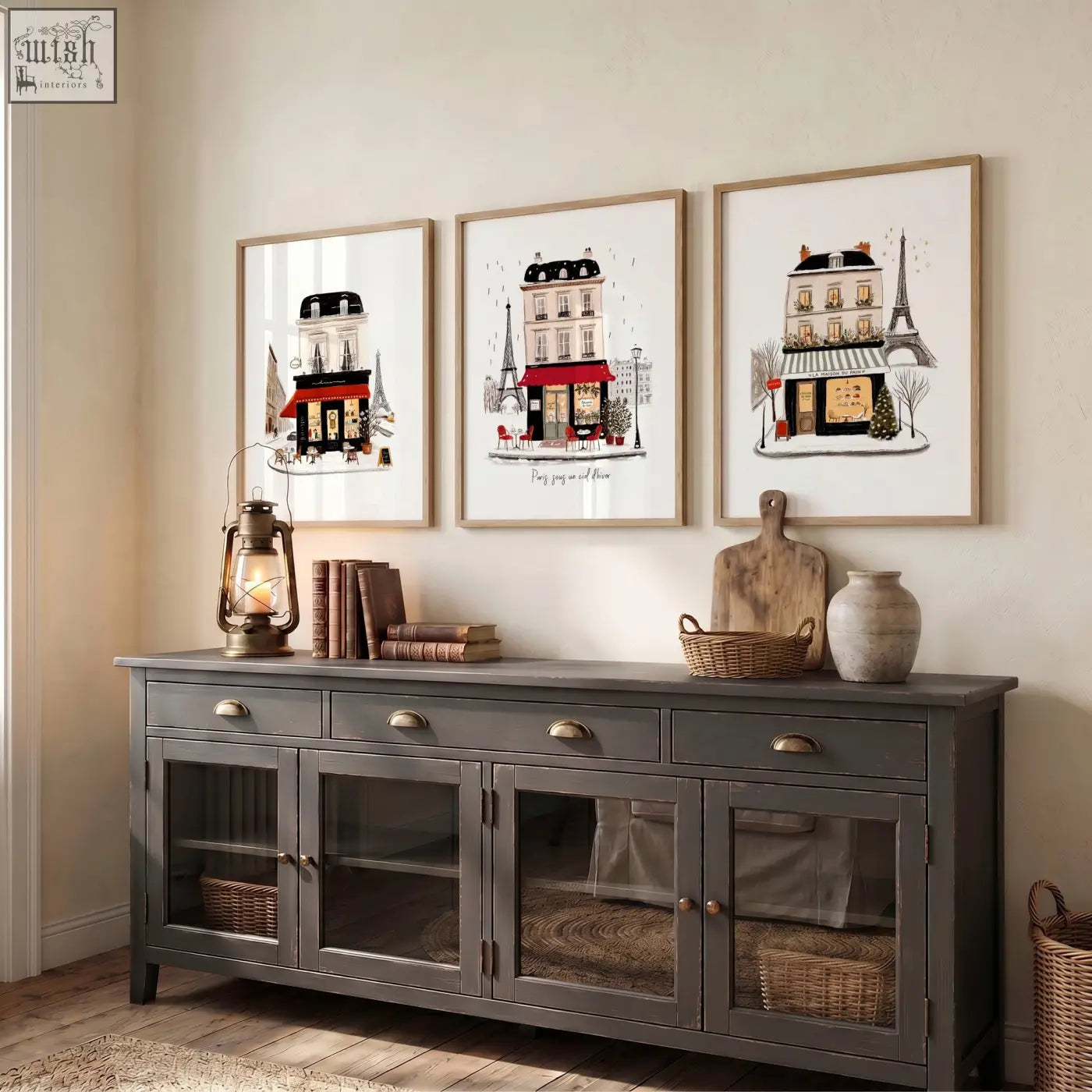Gray wooden sideboard with glass paneled doors and brass handles below paris travel wall art pieces set of 3