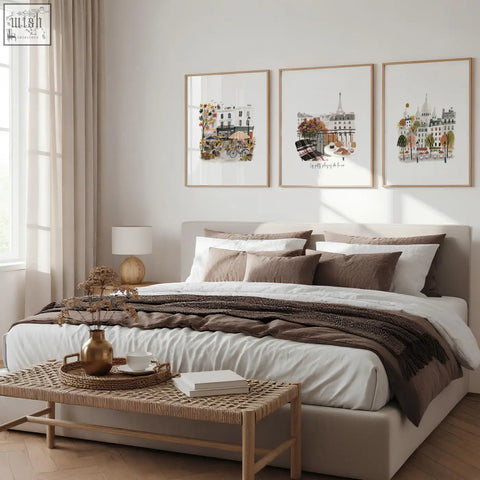 Beige upholstered bed with layered white and brown bedding beside paris wall art autumn watercolour scenes set of 3