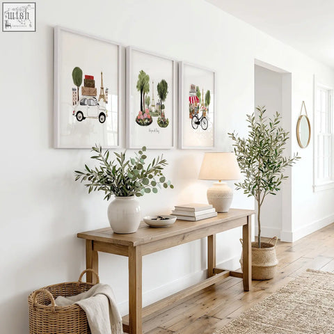 A white ceramic vase with eucalyptus leaves in front of paris wall art featuring the eiffel tower travel prints set