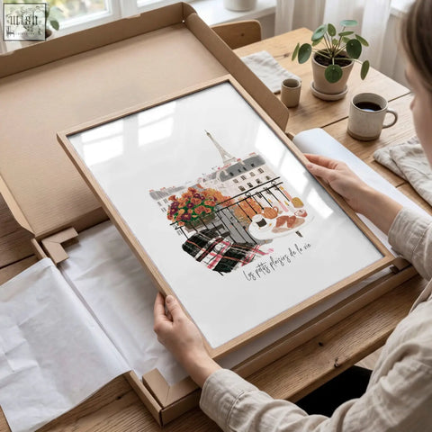 A framed paris wall art in soft watercolor showing a balcony with colorful flowers pastries and the eiffel tower