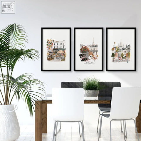 Three framed paris wall art prints with black frames and white mats showing autumn parisian scenes in soft earth tones