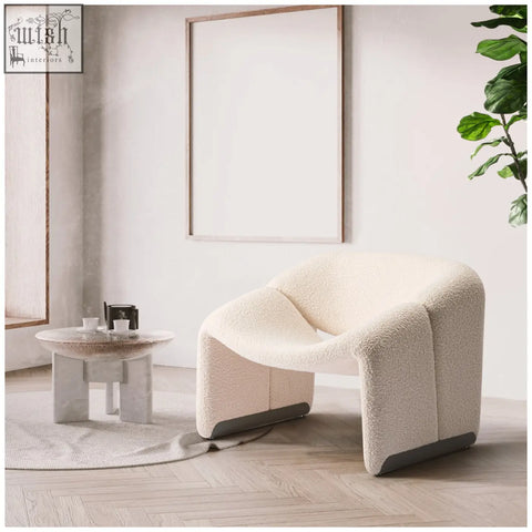 Cream-colored plush paris wawa boucle armchair with modern sculptural design and dark gray base