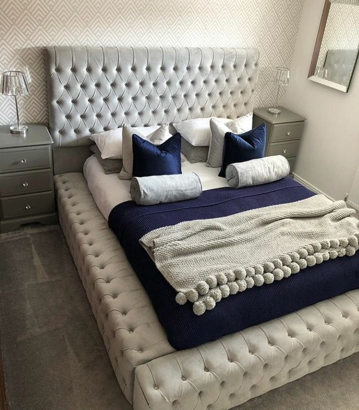 Tufted grey upholstered park lane bed frame with matching platform base and navy blue bedding