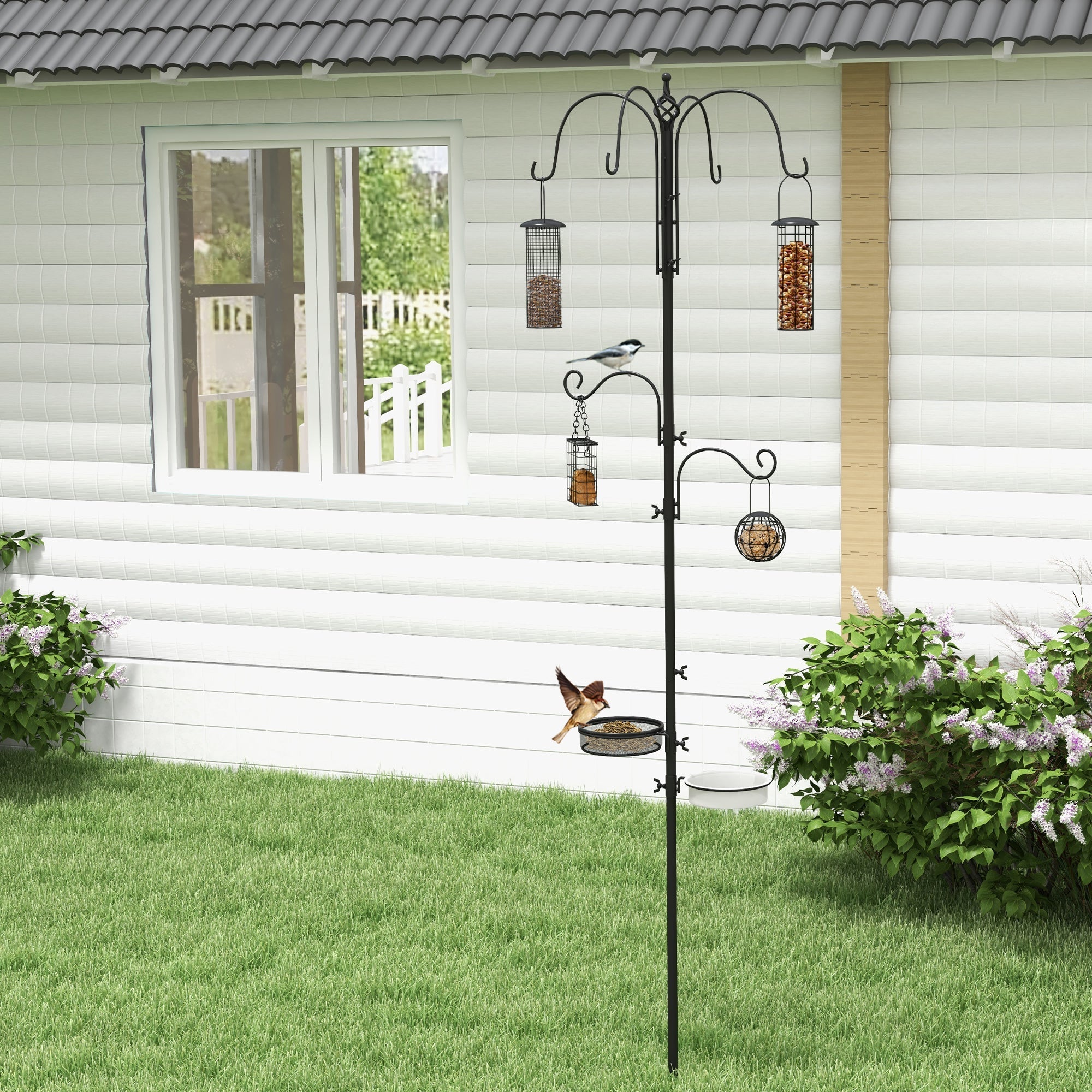 Black metal pawhut bird feeding station with 6 hooks, 4 feeders, and a bird perched for outdoor feeding station use