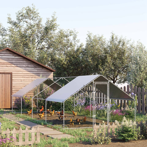 White galvanised steel chicken coop with slanted roof and wire mesh sides in a green garden chicken run