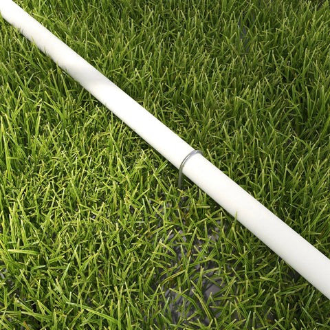 White plastic pipe from pawhut dog agility equipment set lying on green grass with oxford carry bag in background