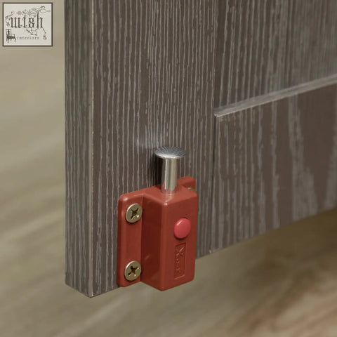 Red plastic door stop with silver lever on pawhut dog crate table with magnetic door for indoor dog cage use