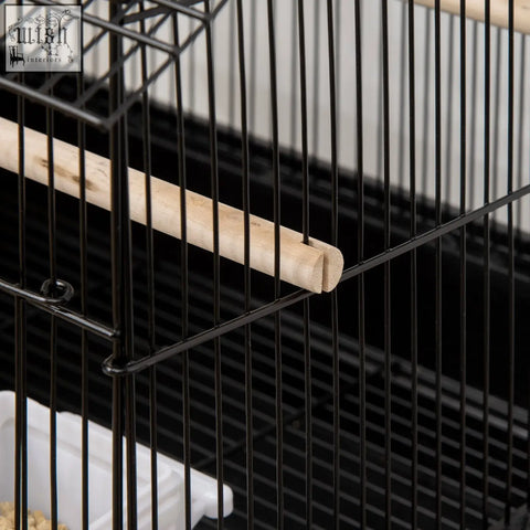 Light wooden perch with rounded end inside black metal pawhut bird cage with plastic food containers for feathered friends