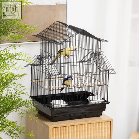 Black metal bird cage with house-shaped roof and plastic food containers housing colorful feathered friends
